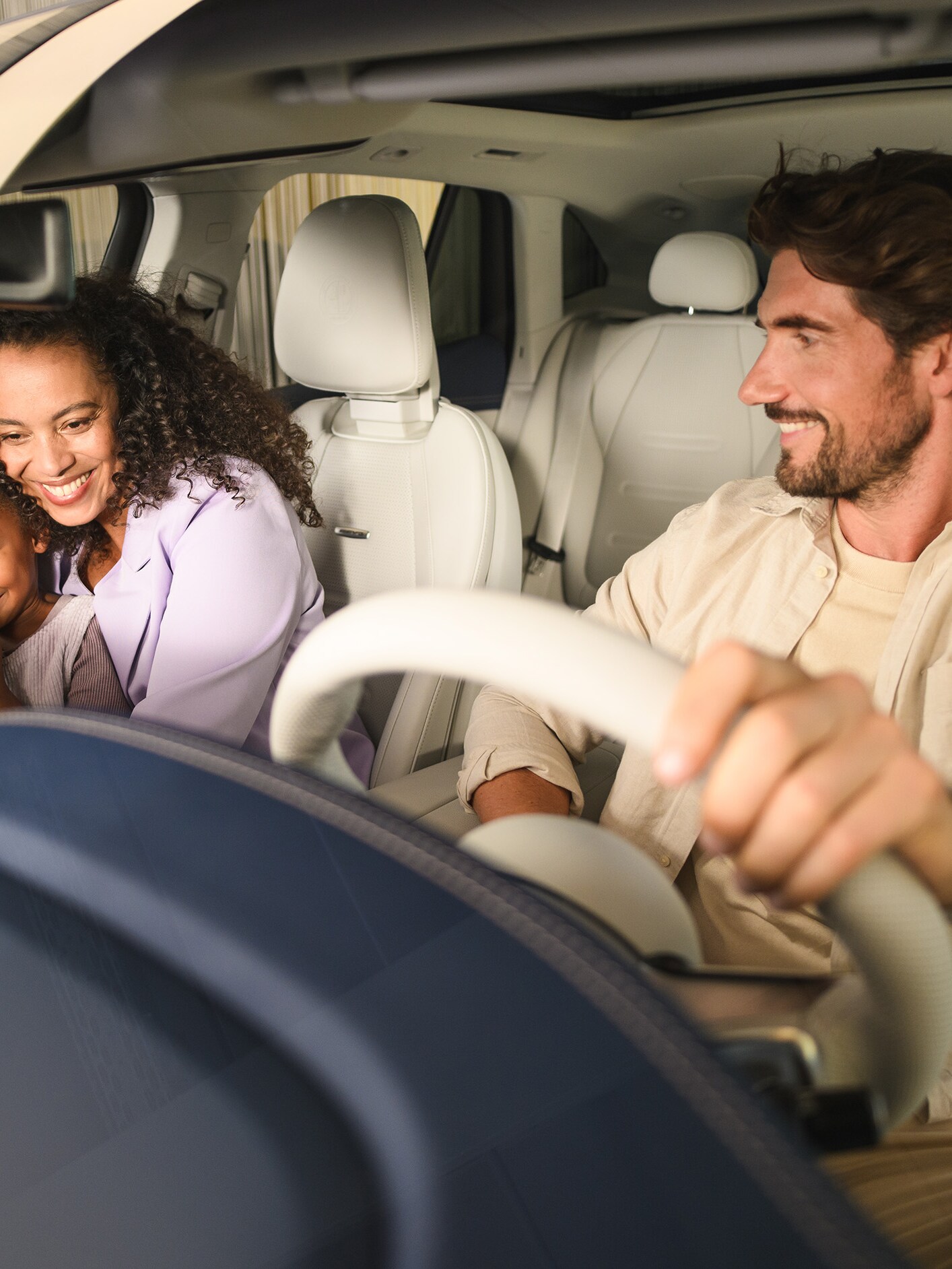 Zwei Personen und ein Kind in einem Mercedes-Benz-Fahrzeug