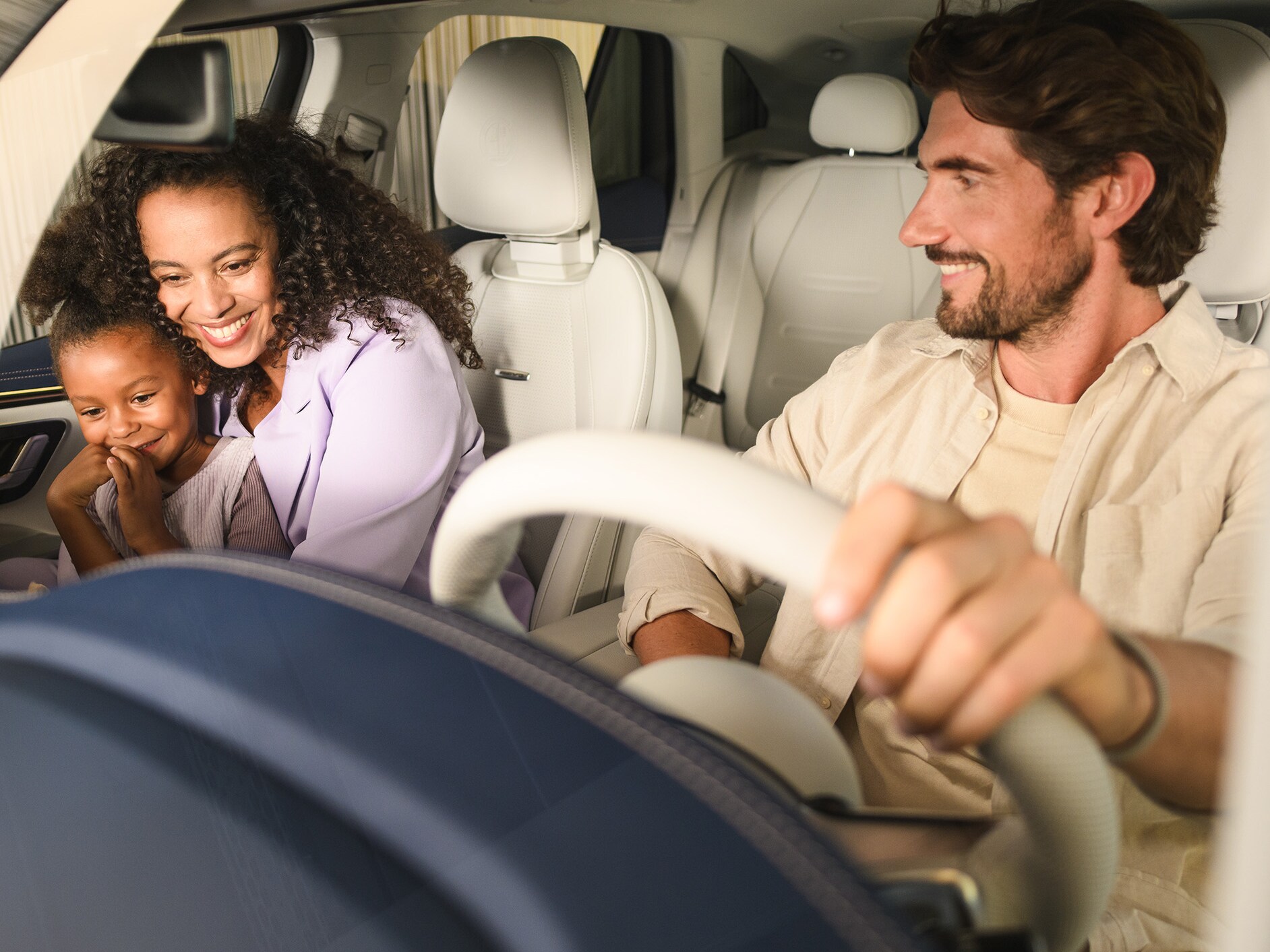 Zwei Personen und ein Kind im Inneren eines Mercedes-Benz Fahrzeugs.