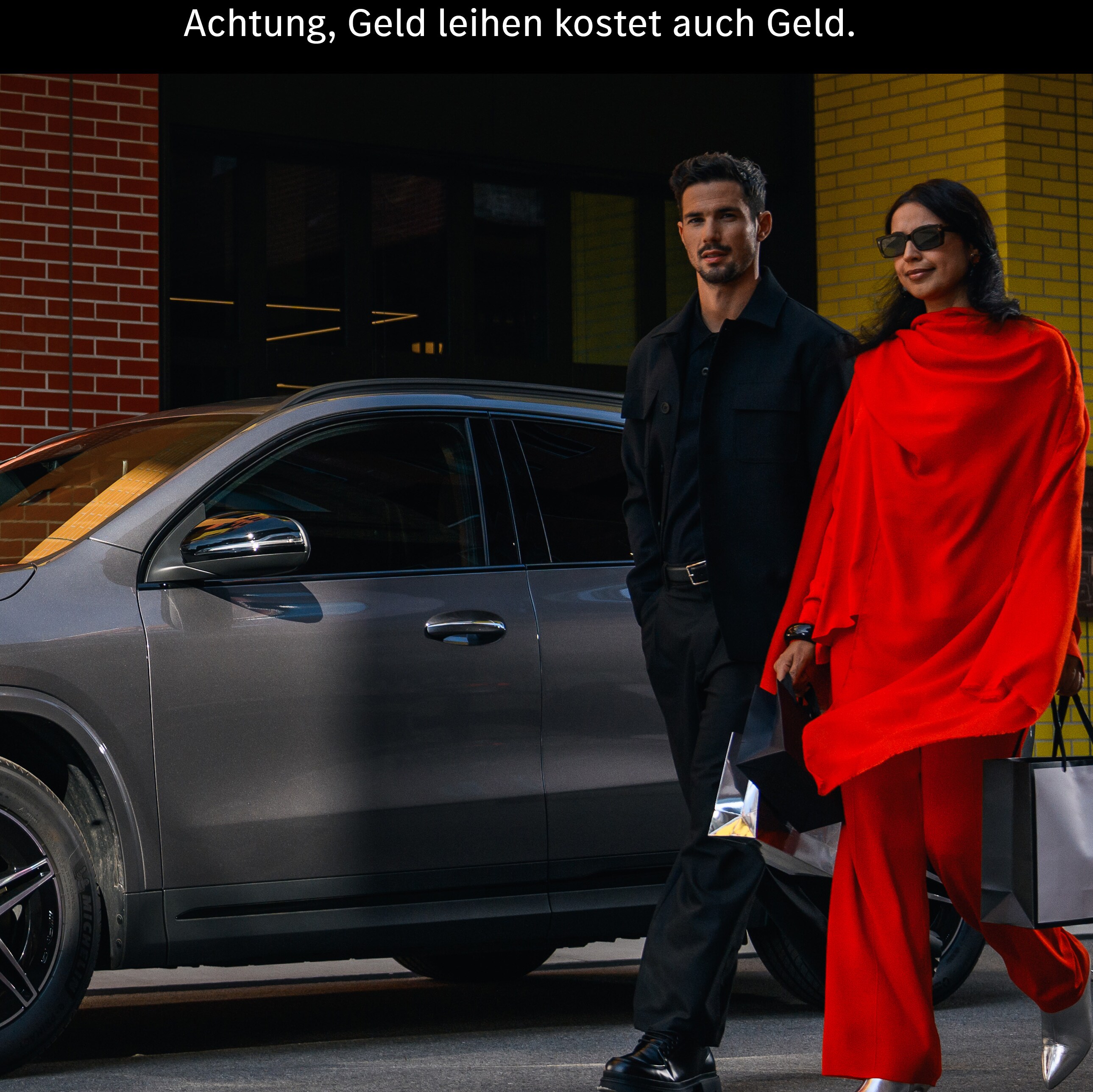 Ein Mann und eine Frau gehen an einem Mercedes EQA vorbei.