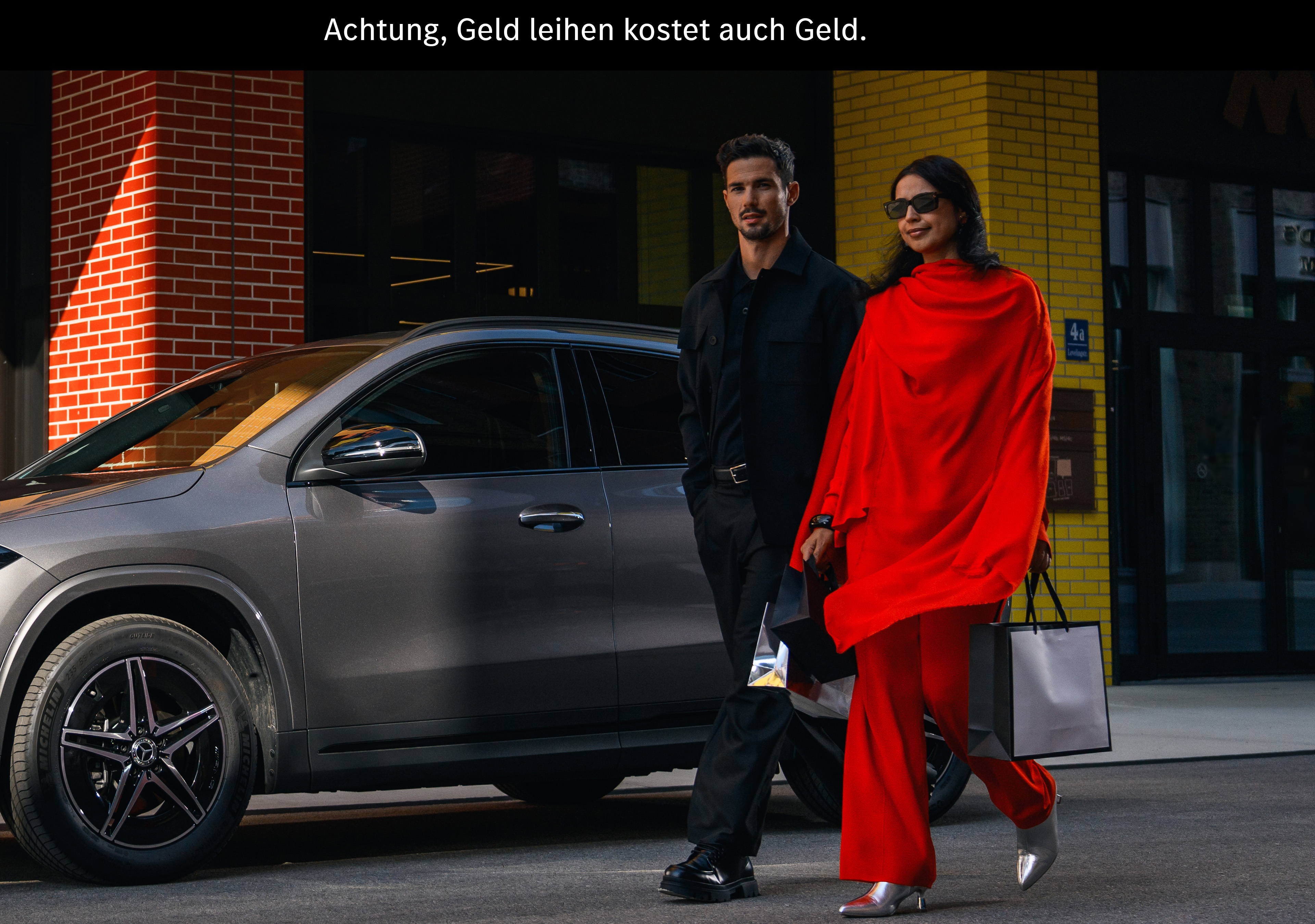 Finanzdienstleistungen für Ihren Mercedes-Benz Ein Mann und eine Frau gehen an einem Mercedes EQA vorbei.