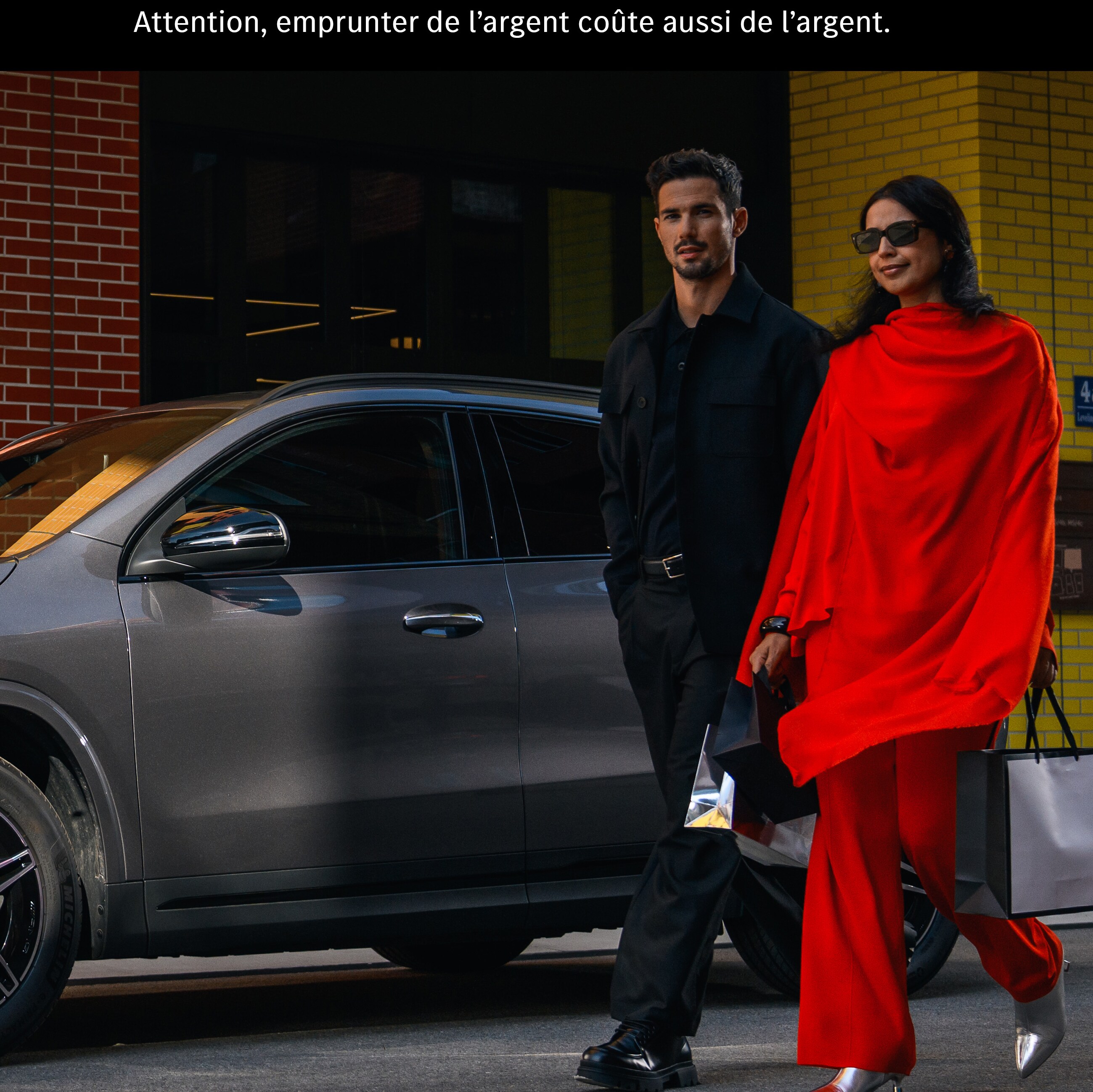 Un couple passe devant une Mercedes EQA.