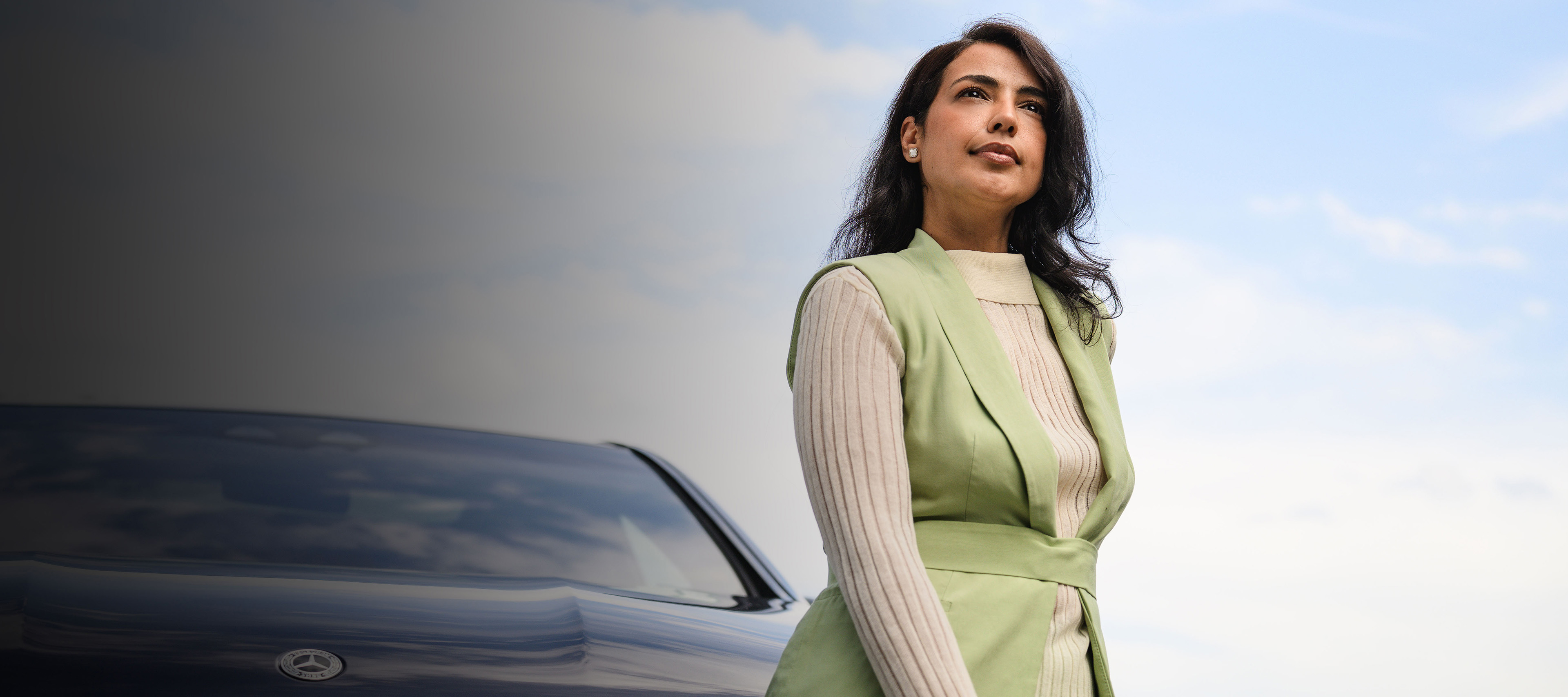 Vertragsbeendigungsverfahren für Ihren Mercedes-Benz Eine Person steht vor einem Mercedes-Benz Fahrzeug und schaut in die Ferne.