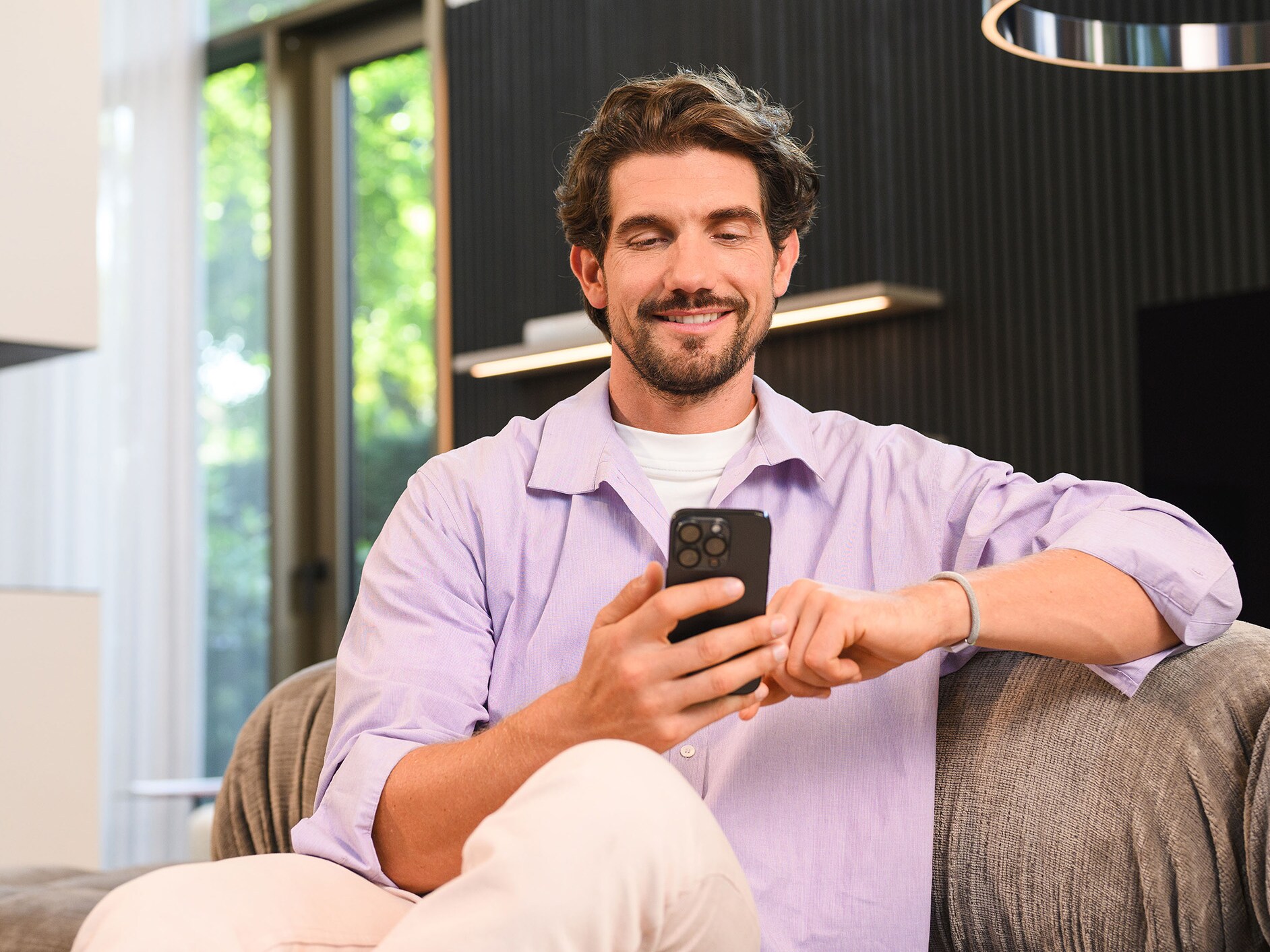 Une personne assise utilisant un appareil mobile.