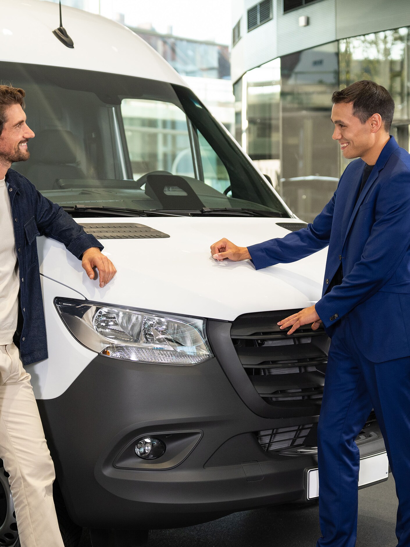 Deux personnes appuyées contre un utilitaire Mercedes-Benz et en train de discuter.