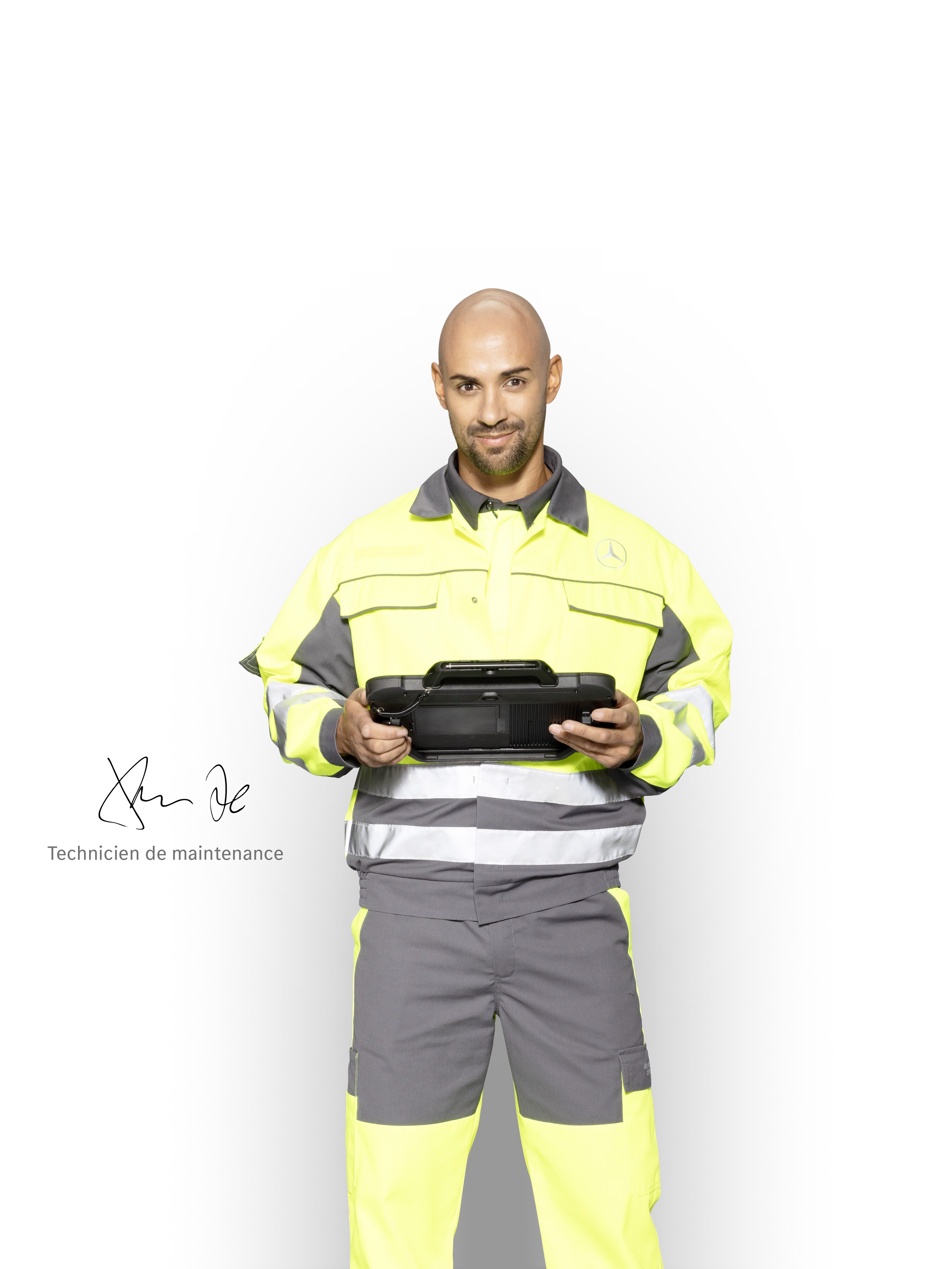 Technicien de maintenance en tenue de travail, tablette à la main, pour assurer un soutien compétent de la part de Mercedes-Benz .