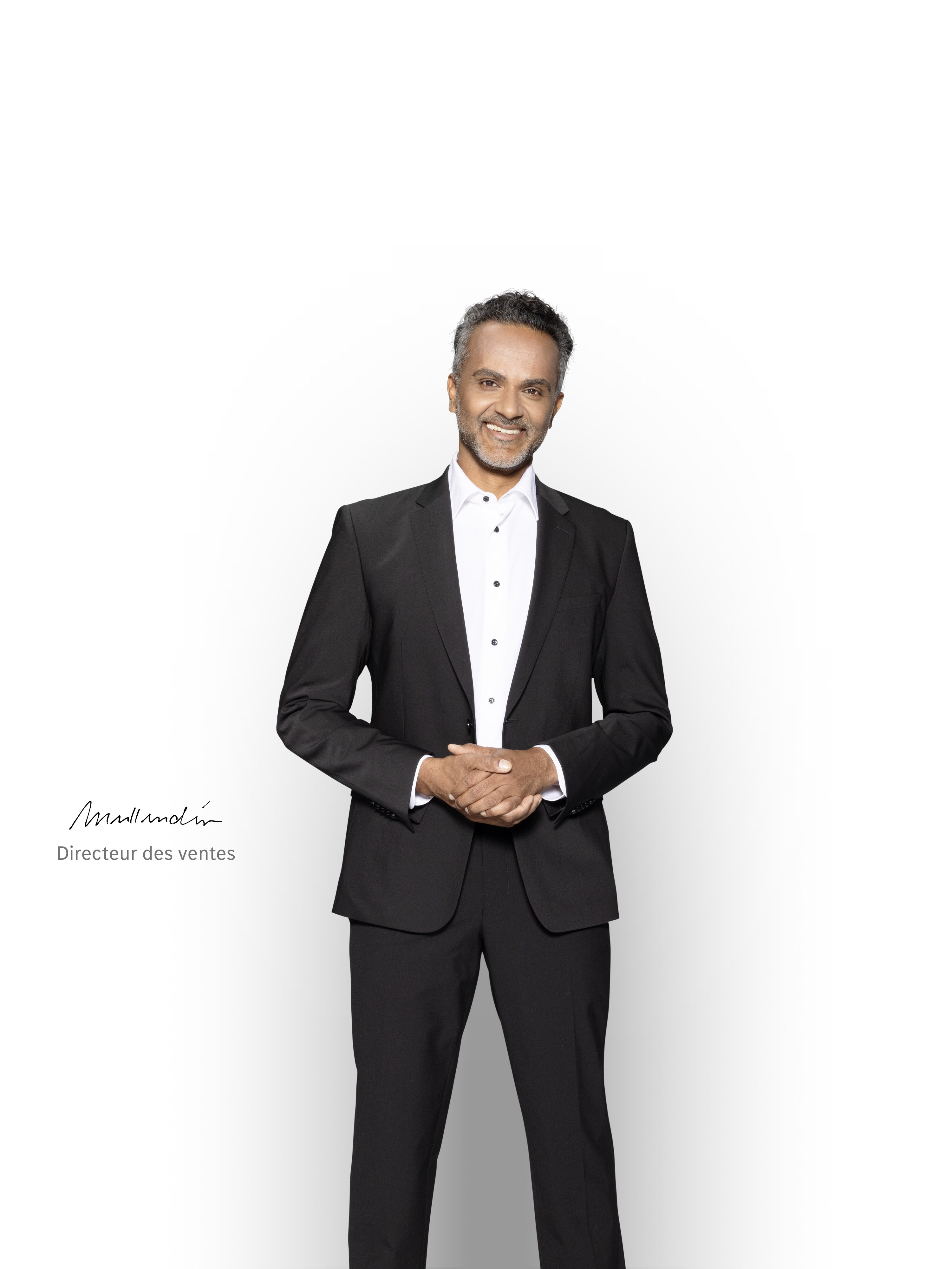 Un directeur des ventes compétent se tient debout et sourit pour assurer le support technique de votre utilitaire léger électrique Mercedes-Benz.