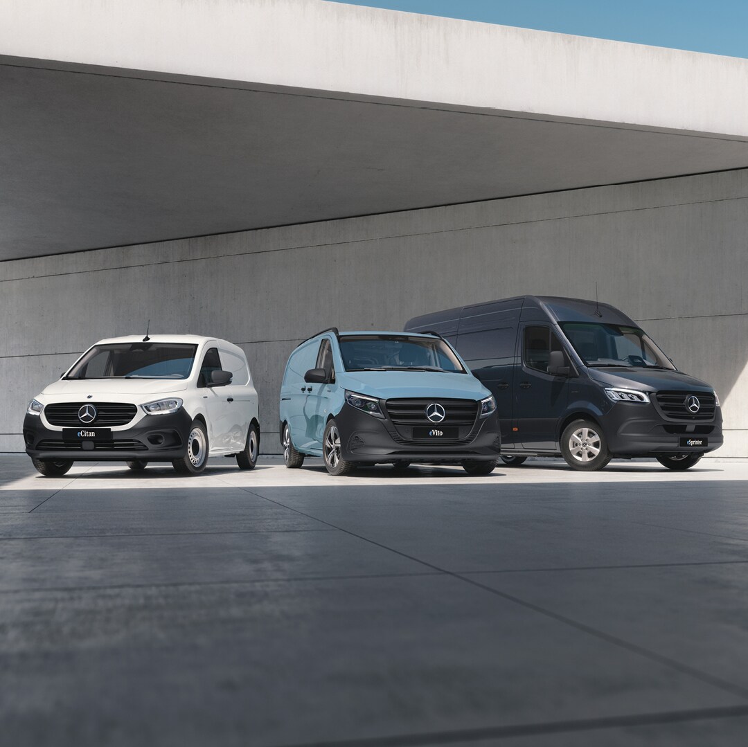 Drei Mercedes-Benz Transporter unter einem Unterstand geparkt.