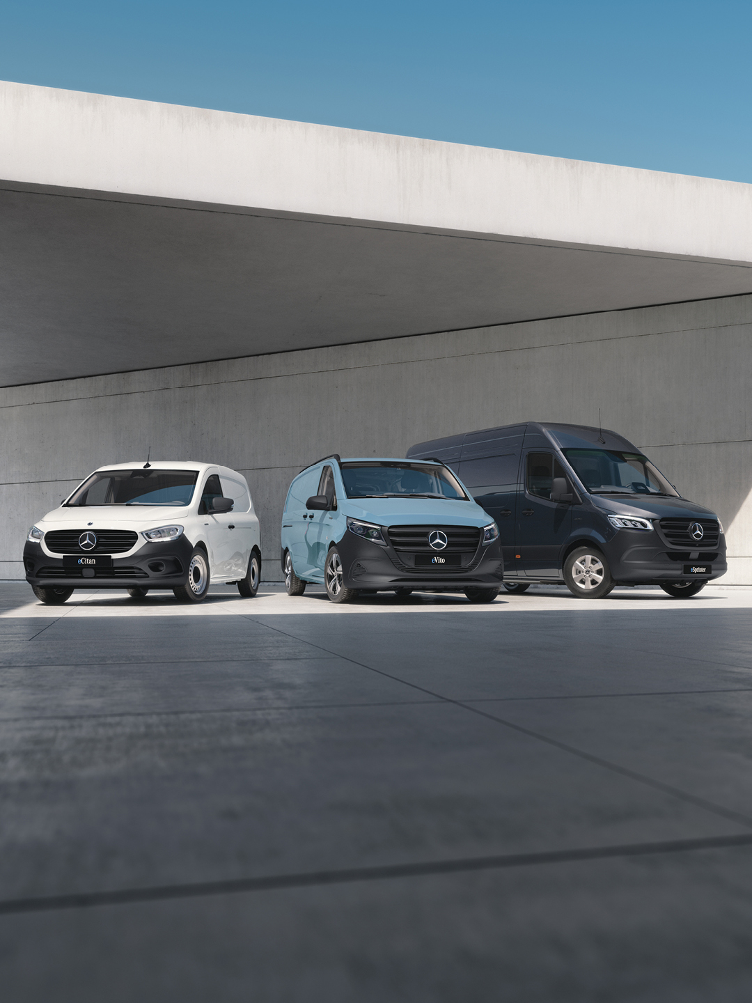 Drei Mercedes-Benz Transporter unter einem Unterstand geparkt.