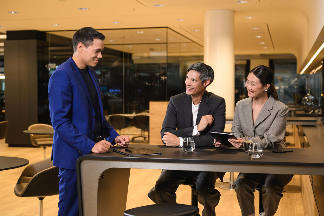Entretien de conseil sur les véhicules utilitaires. Des clients professionnels discutent de véhicules utilitaires avec un conseiller Mercedes-Benz.