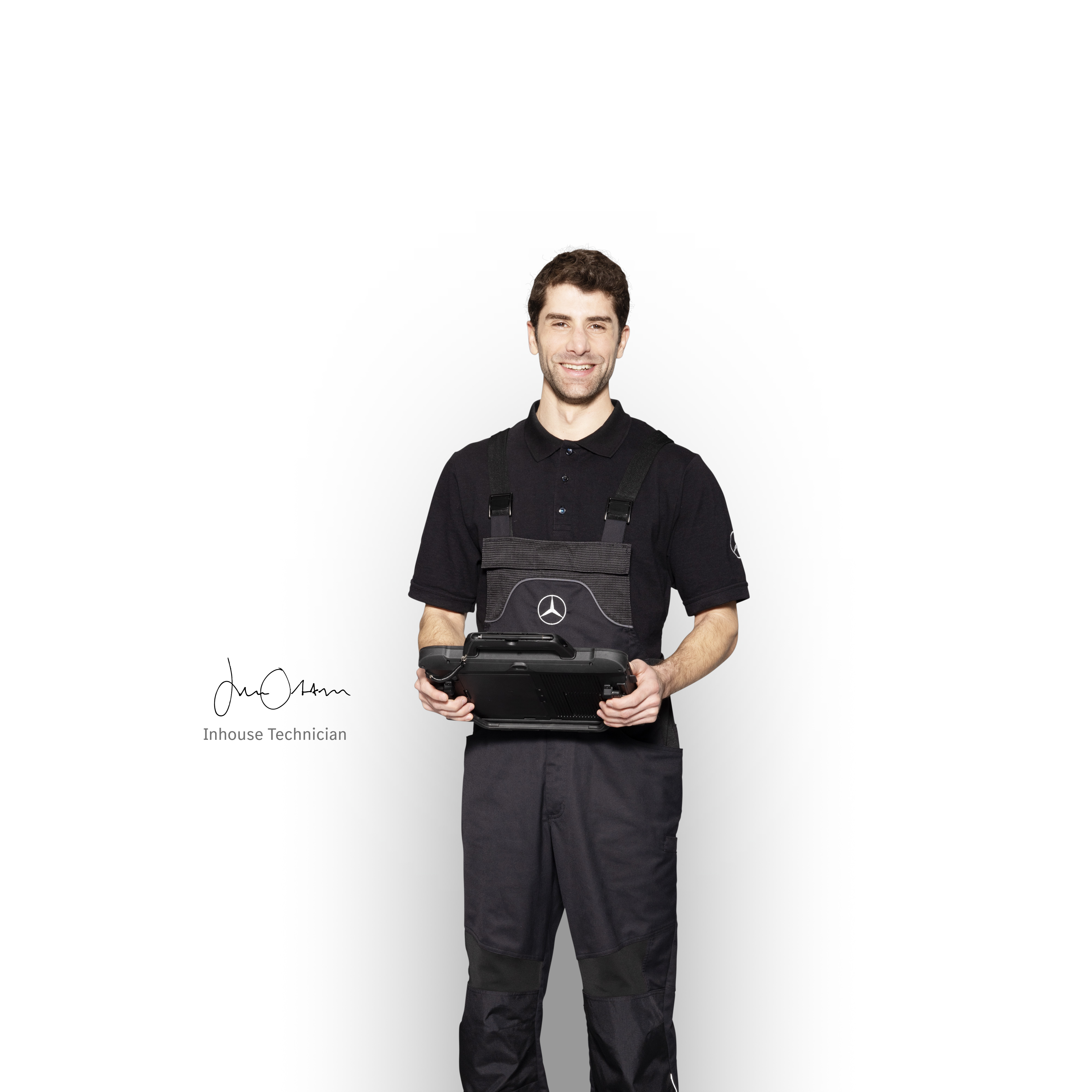 Mercedes-Benz | Aperçu des services Mécanicien Mercedes-Benz en tenue de travail, tenant une tablette prête pour le signalement des dommages.