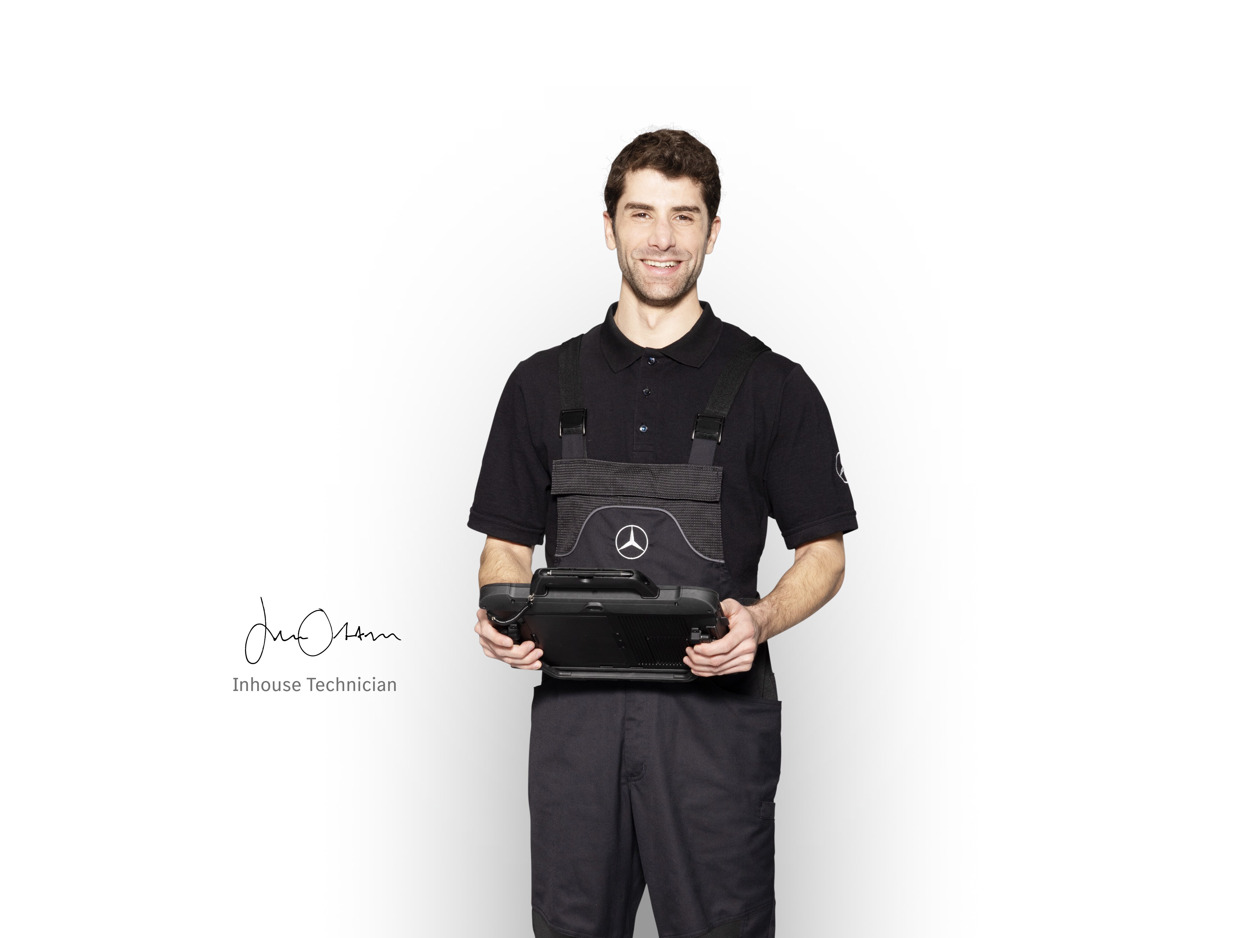 Mercedes-Benz Mechaniker in Arbeitskleidung hält ein Tablet für die Schadensmeldung bereit.